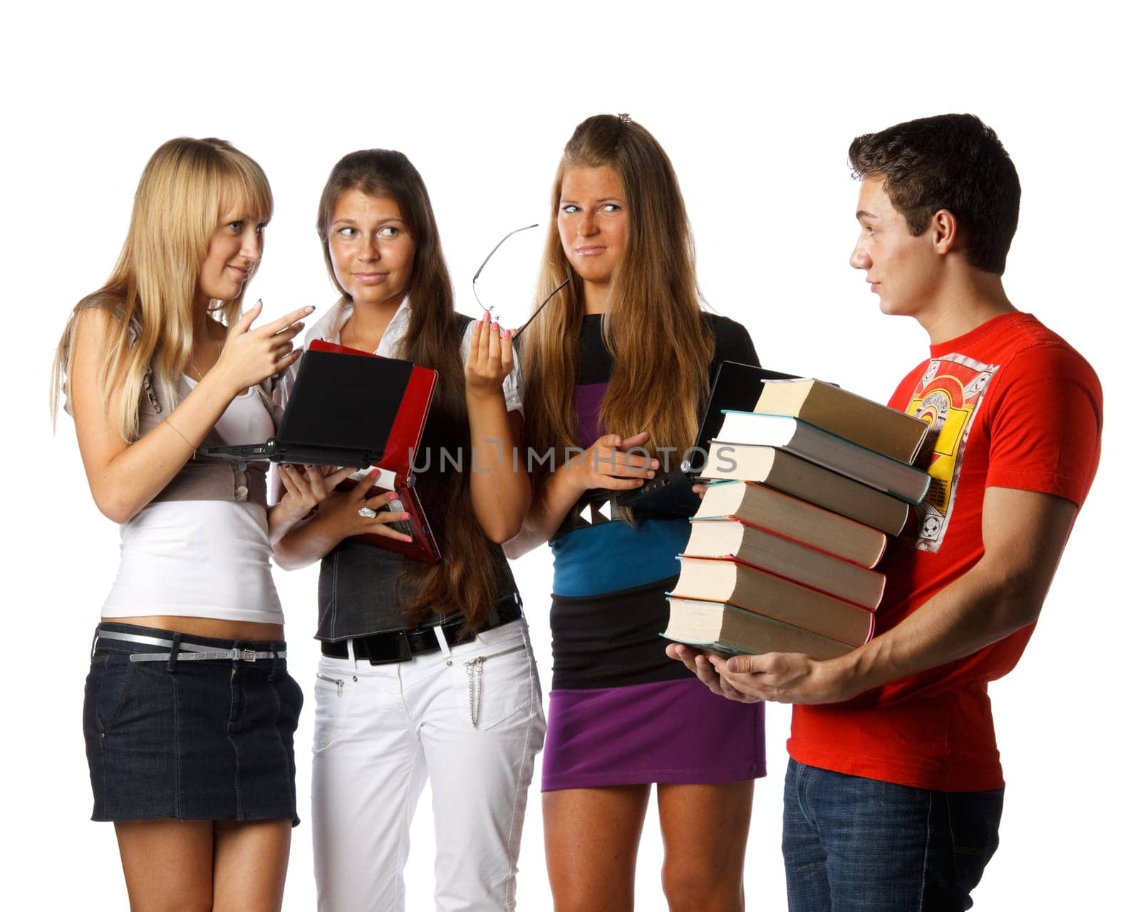Three beautiful students with laptops discuss the young man with the big pile of books on a white background.