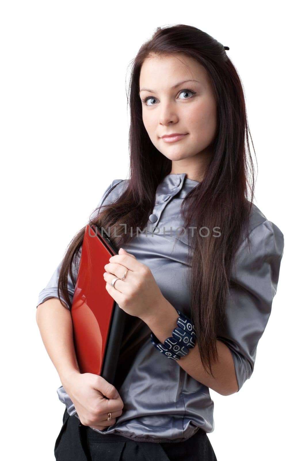 The attractive student stands with the laptop on a white background.