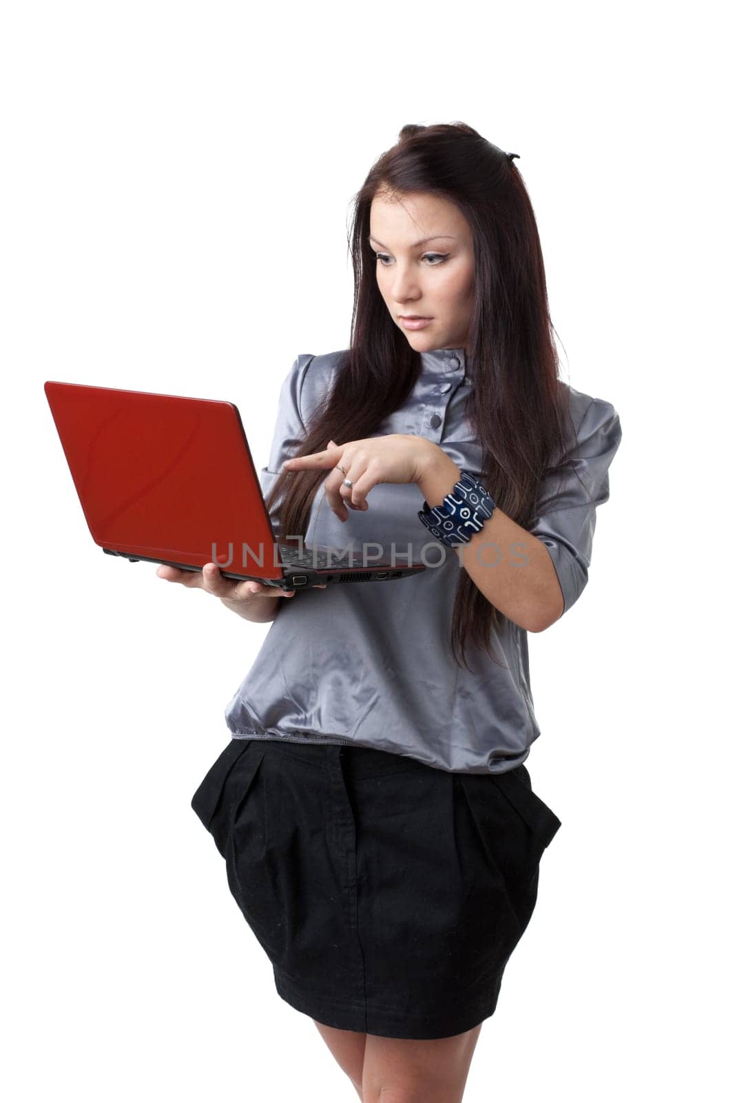 The attractive student stands with the laptop on a white background.
