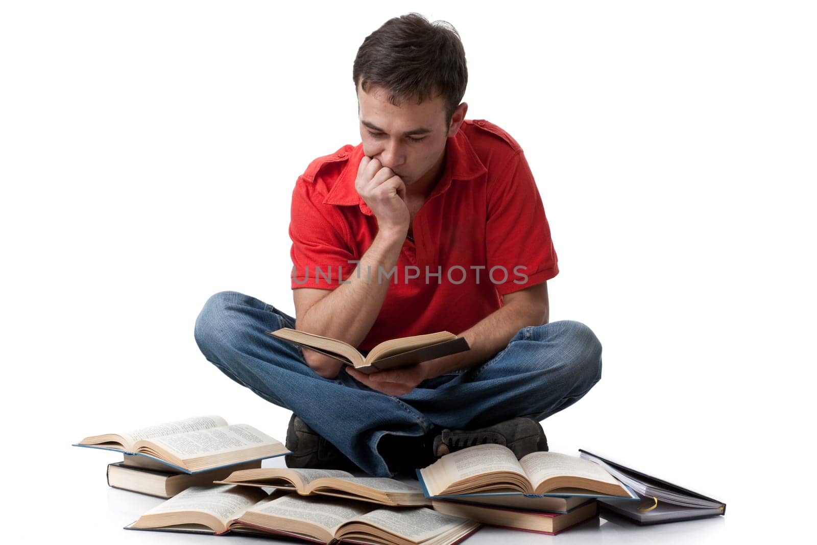 The clever young man sitting with books on a white background.