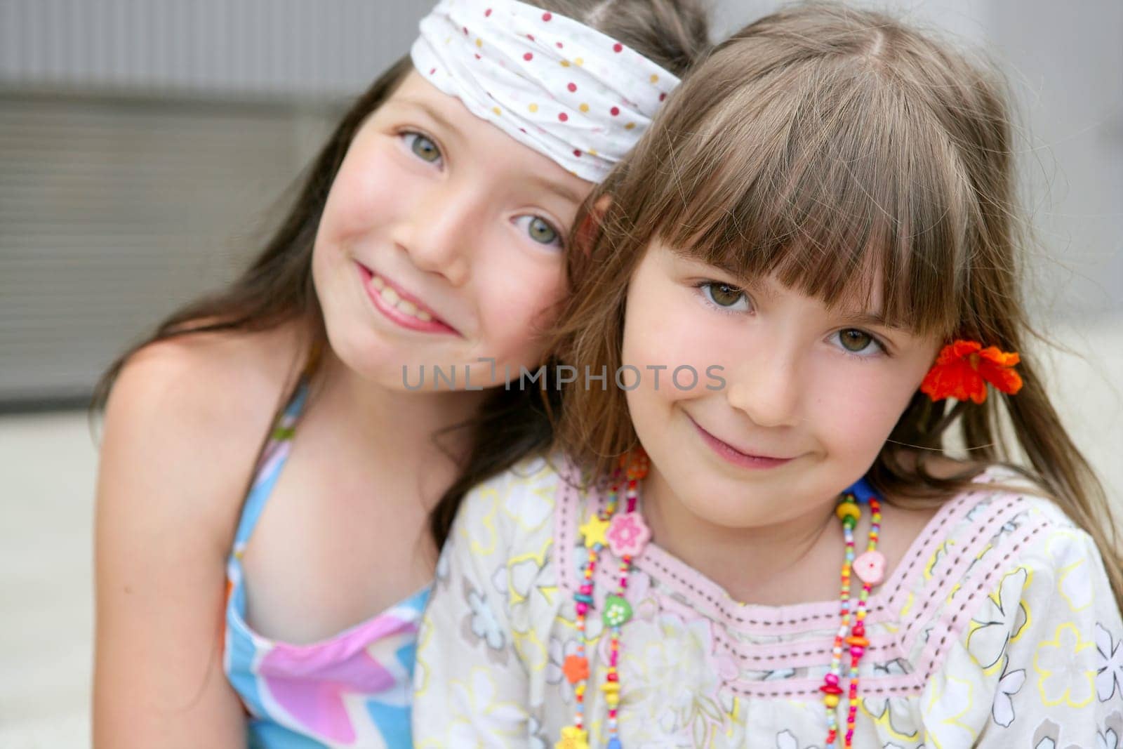 closeup portrait of two little happy beautiful girl sisters