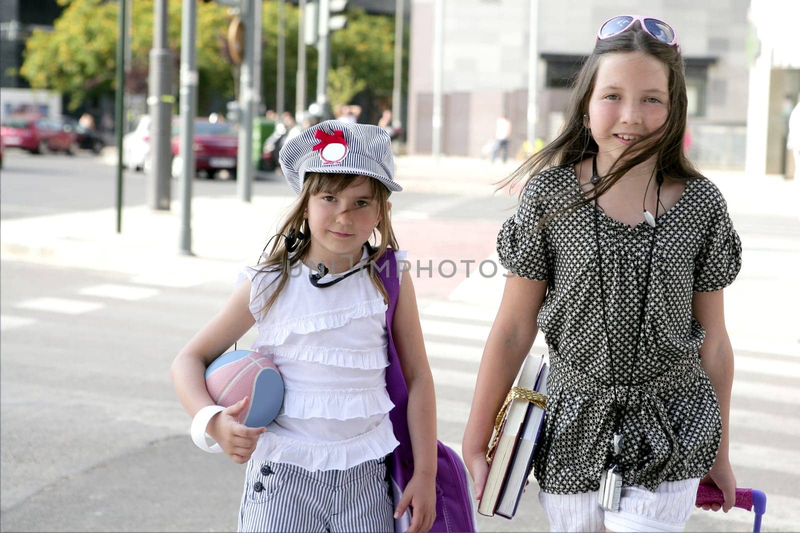 Little girls going to school with bags, books and student stuff