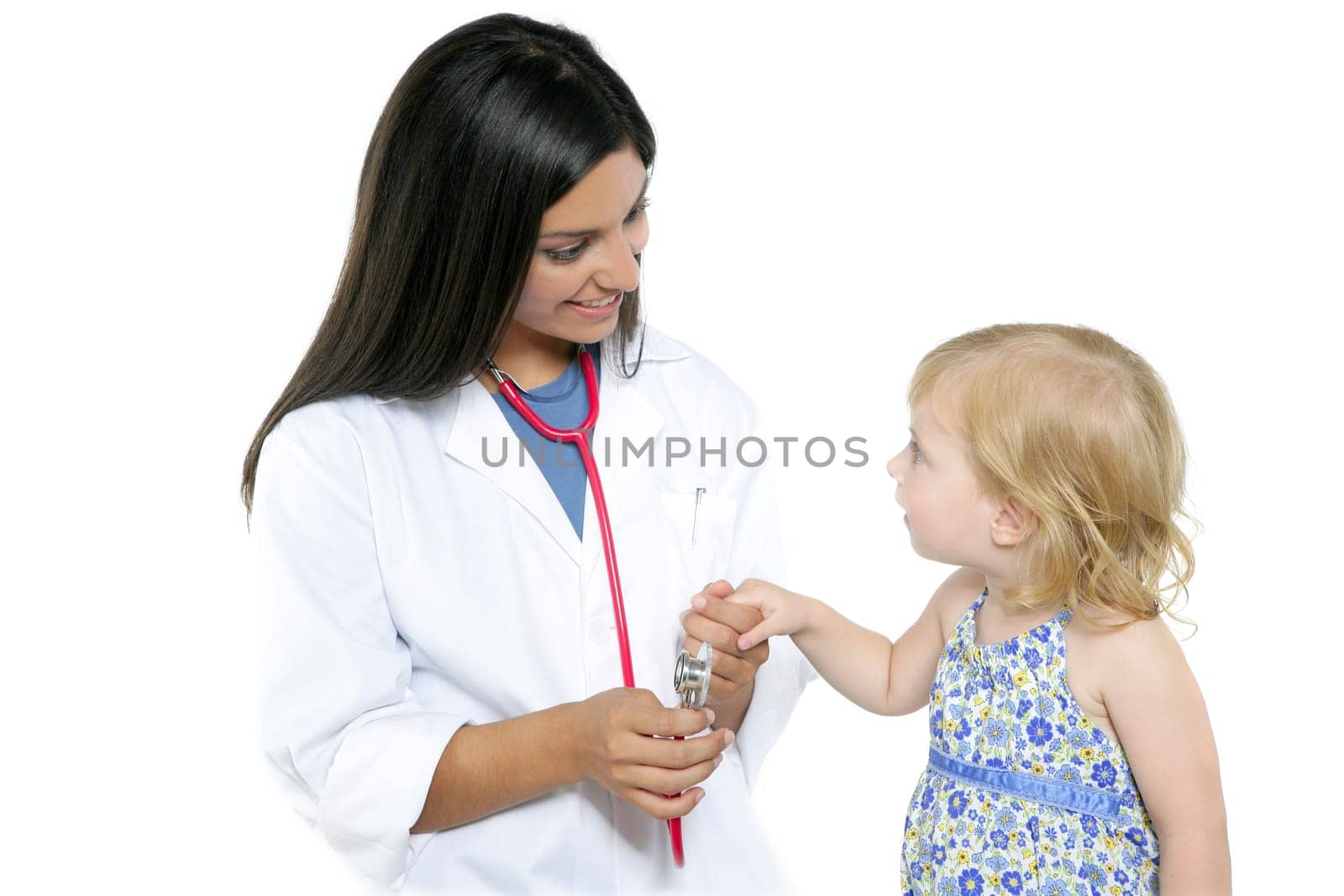 Brunette pediatric doctor with blond little girl on medical exam