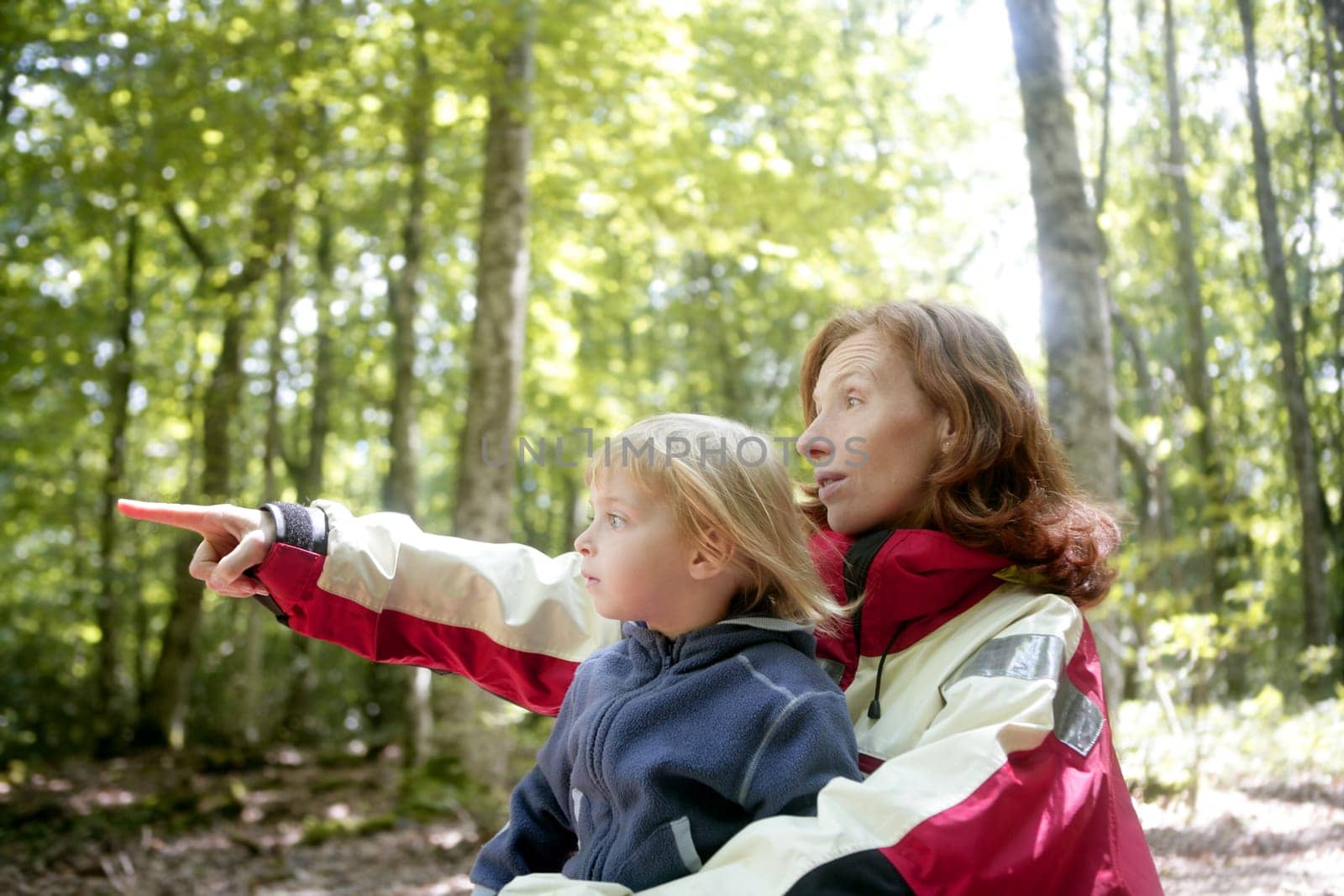 Beautiful blond little daughter with her mother inn the forest