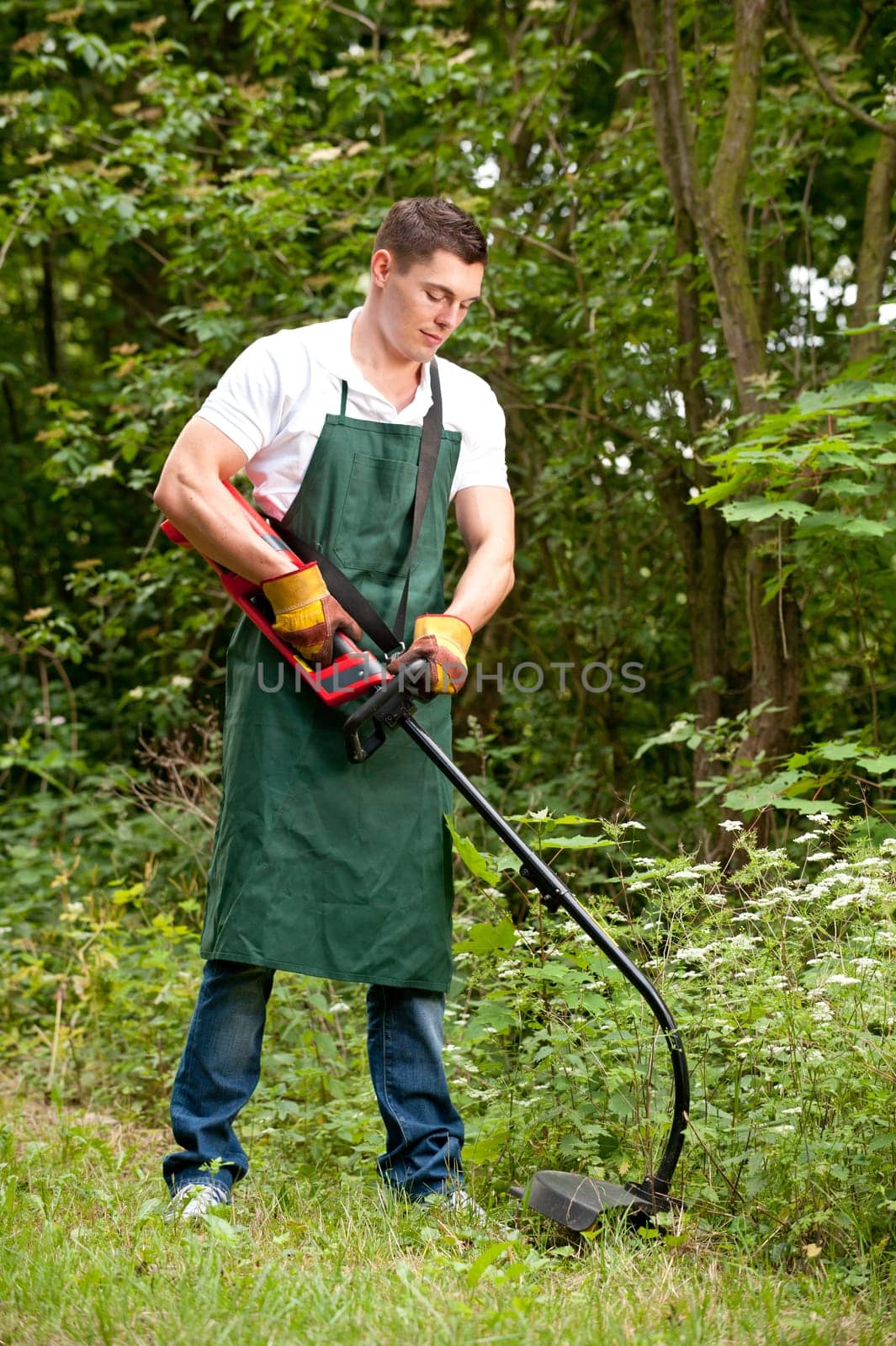 Young gardener with a lawn trimmer