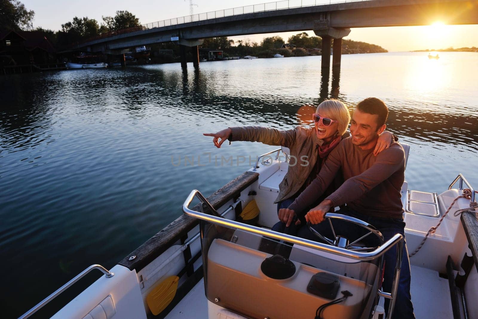 happy young couple in love  have romantic time at summer sunset   at ship boat while  representing urban and countryside fashin lifestyle