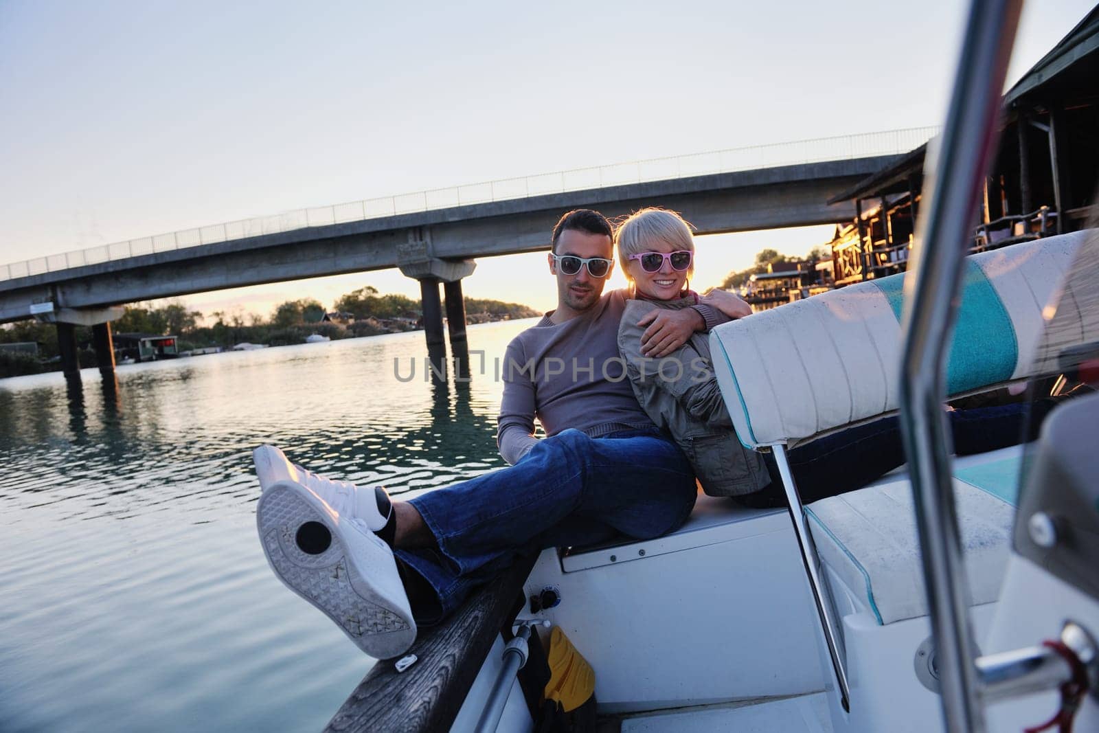 happy young couple in love  have romantic time at summer sunset   at ship boat while  representing urban and countryside fashin lifestyle