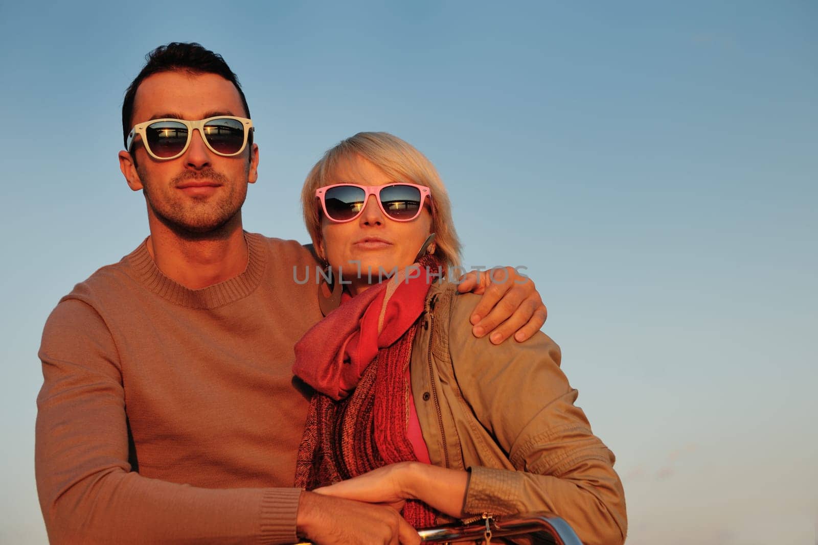 happy young couple in love  have romantic time at summer sunset   at ship boat while  representing urban and countryside fashin lifestyle