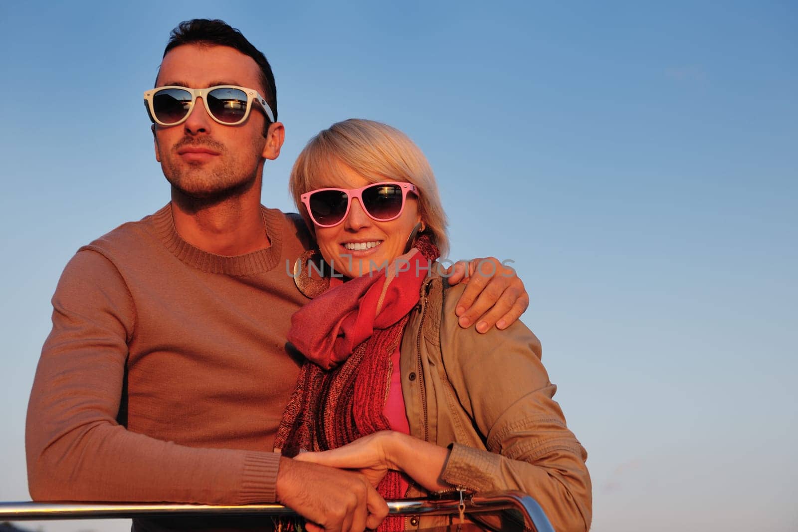 happy young couple in love  have romantic time at summer sunset   at ship boat while  representing urban and countryside fashin lifestyle