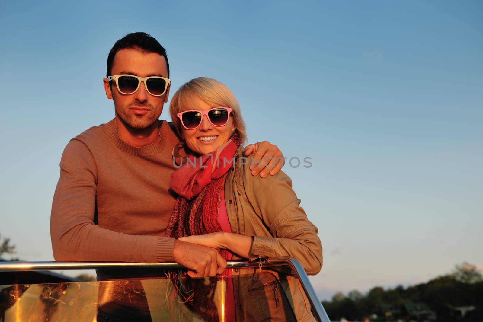 happy young couple in love  have romantic time at summer sunset   at ship boat while  representing urban and countryside fashin lifestyle