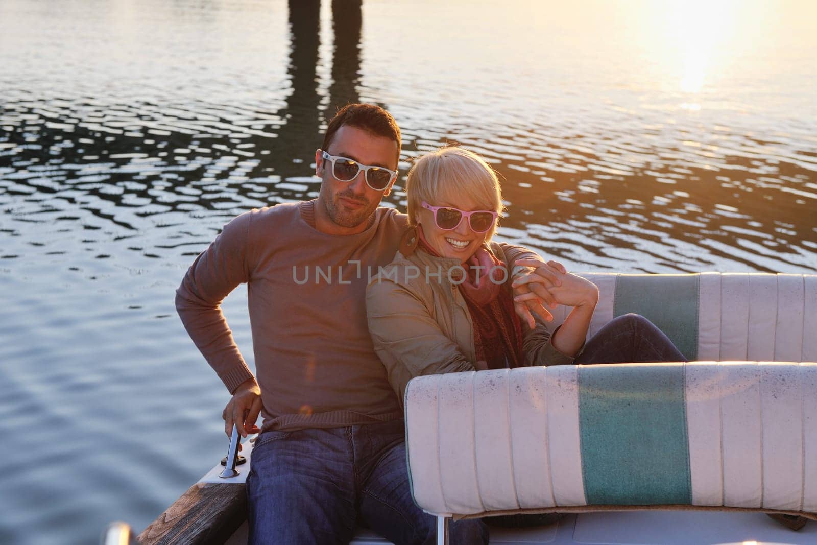 happy young couple in love  have romantic time at summer sunset   at ship boat while  representing urban and countryside fashin lifestyle