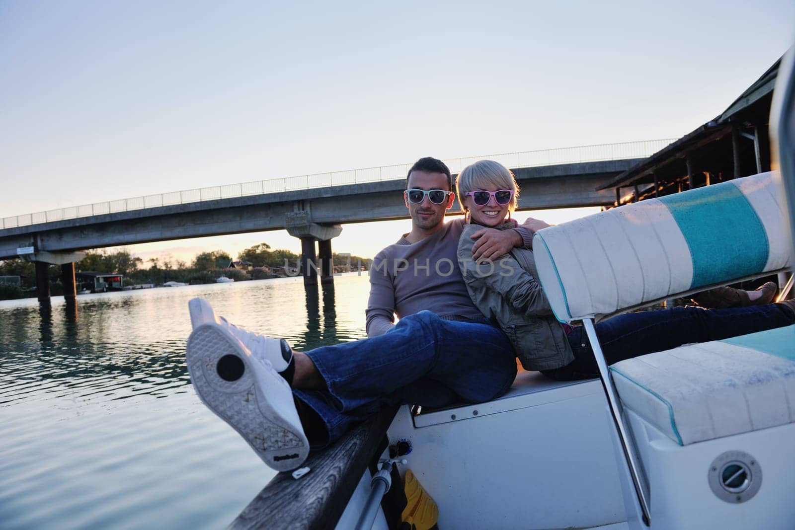 happy young couple in love  have romantic time at summer sunset   at ship boat while  representing urban and countryside fashin lifestyle