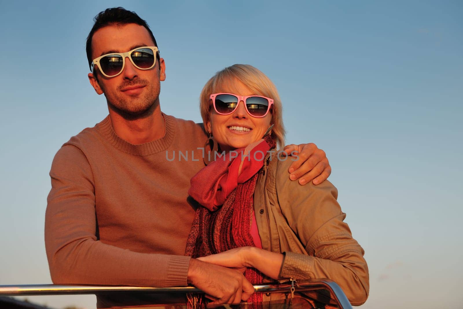 happy young couple in love  have romantic time at summer sunset   at ship boat while  representing urban and countryside fashin lifestyle