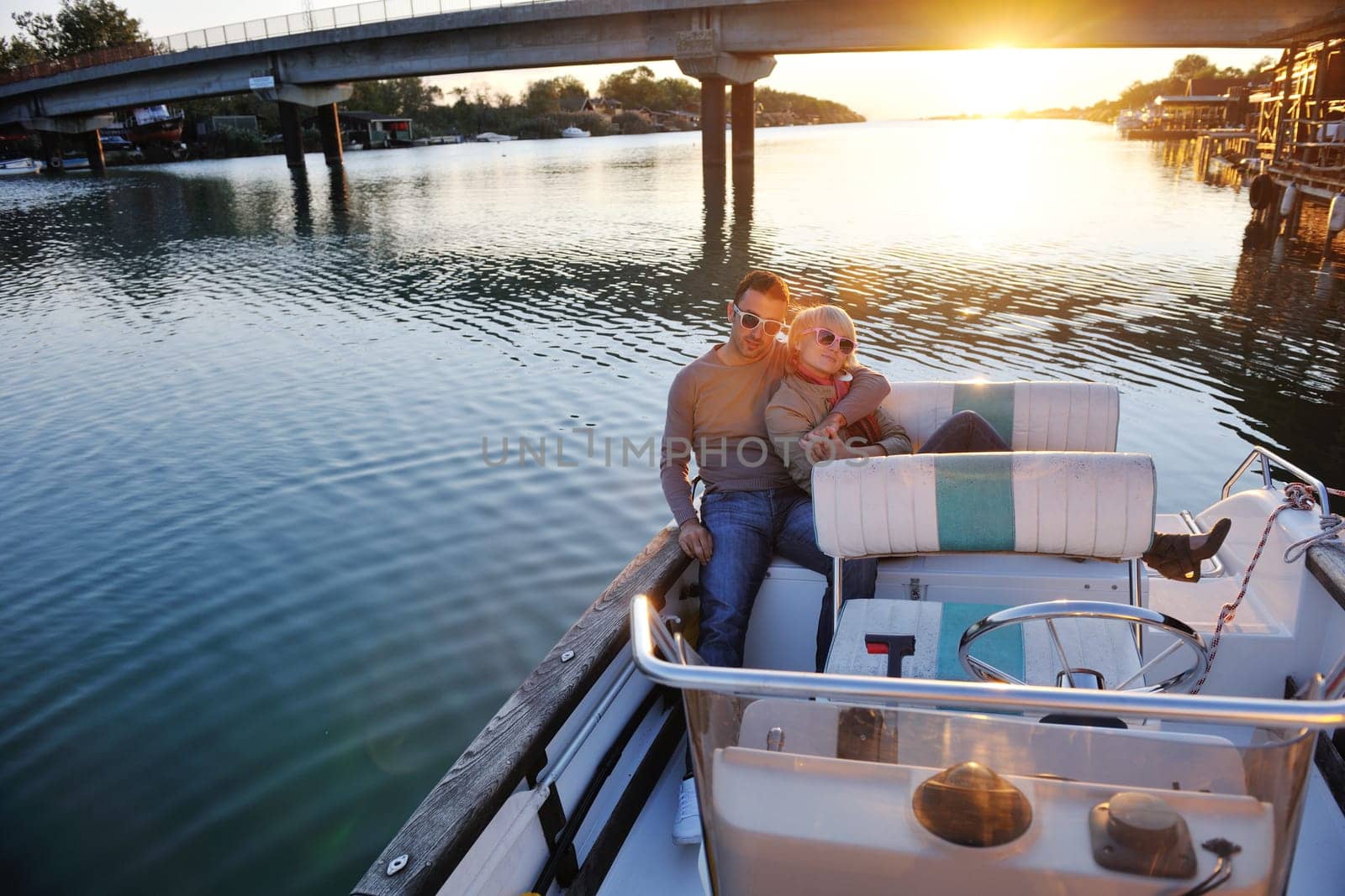 happy young couple in love  have romantic time at summer sunset   at ship boat while  representing urban and countryside fashin lifestyle