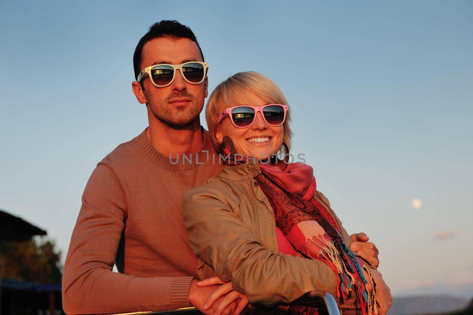 happy young couple in love  have romantic time at summer sunset   at ship boat while  representing urban and countryside fashin lifestyle