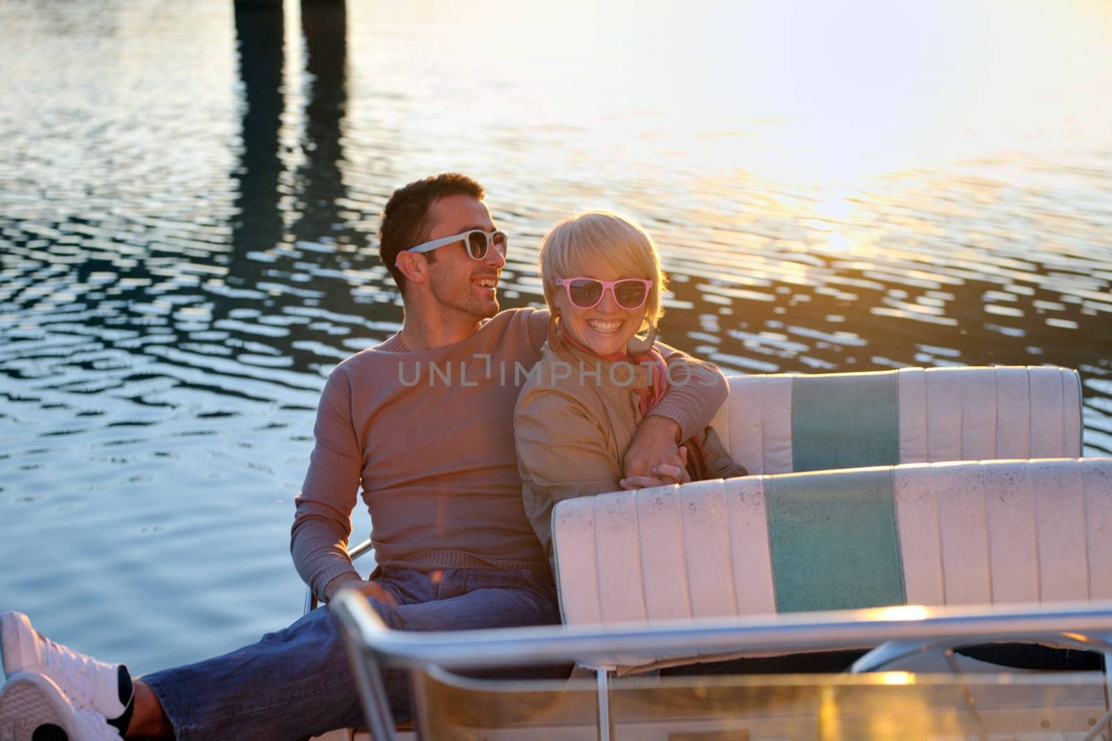 happy young couple in love  have romantic time at summer sunset   at ship boat while  representing urban and countryside fashin lifestyle