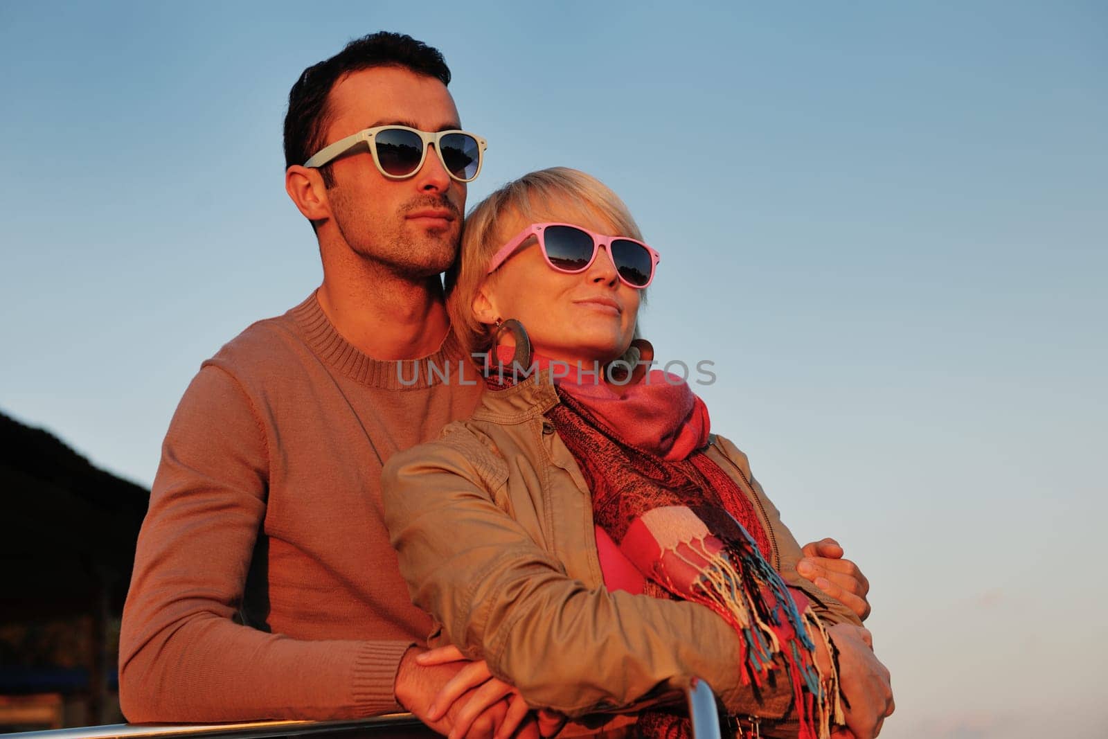 happy young couple in love  have romantic time at summer sunset   at ship boat while  representing urban and countryside fashin lifestyle
