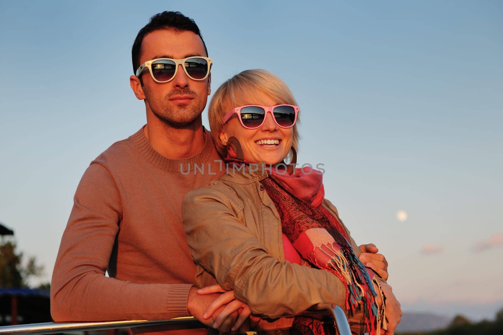 happy young couple in love  have romantic time at summer sunset   at ship boat while  representing urban and countryside fashin lifestyle