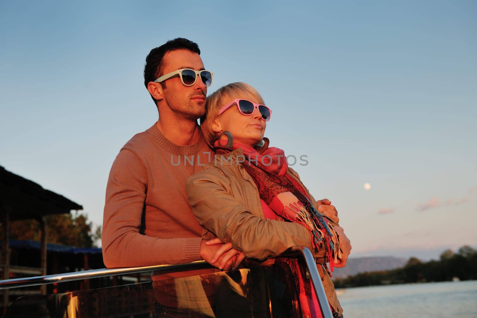 happy young couple in love  have romantic time at summer sunset   at ship boat while  representing urban and countryside fashin lifestyle
