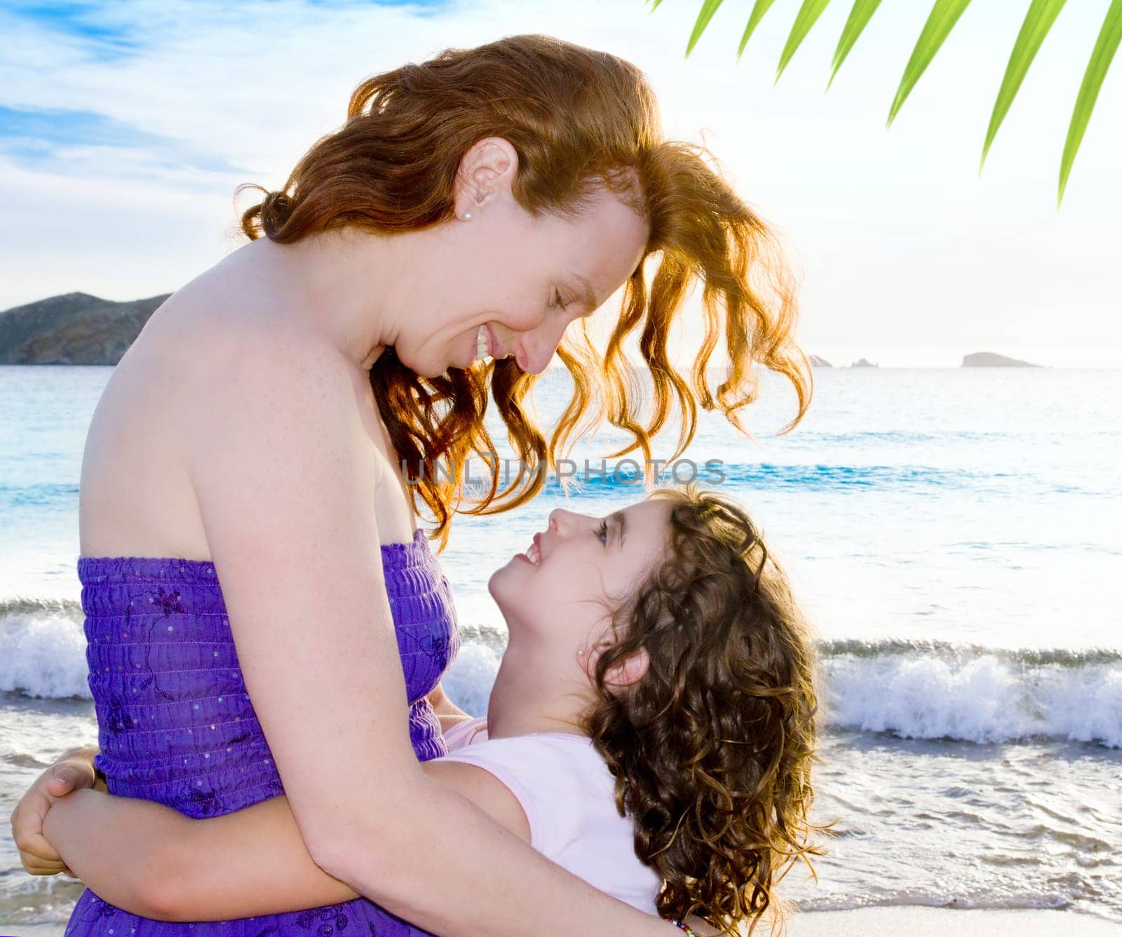 Daughter and mother hug on the beach of Ibiza Cala conta