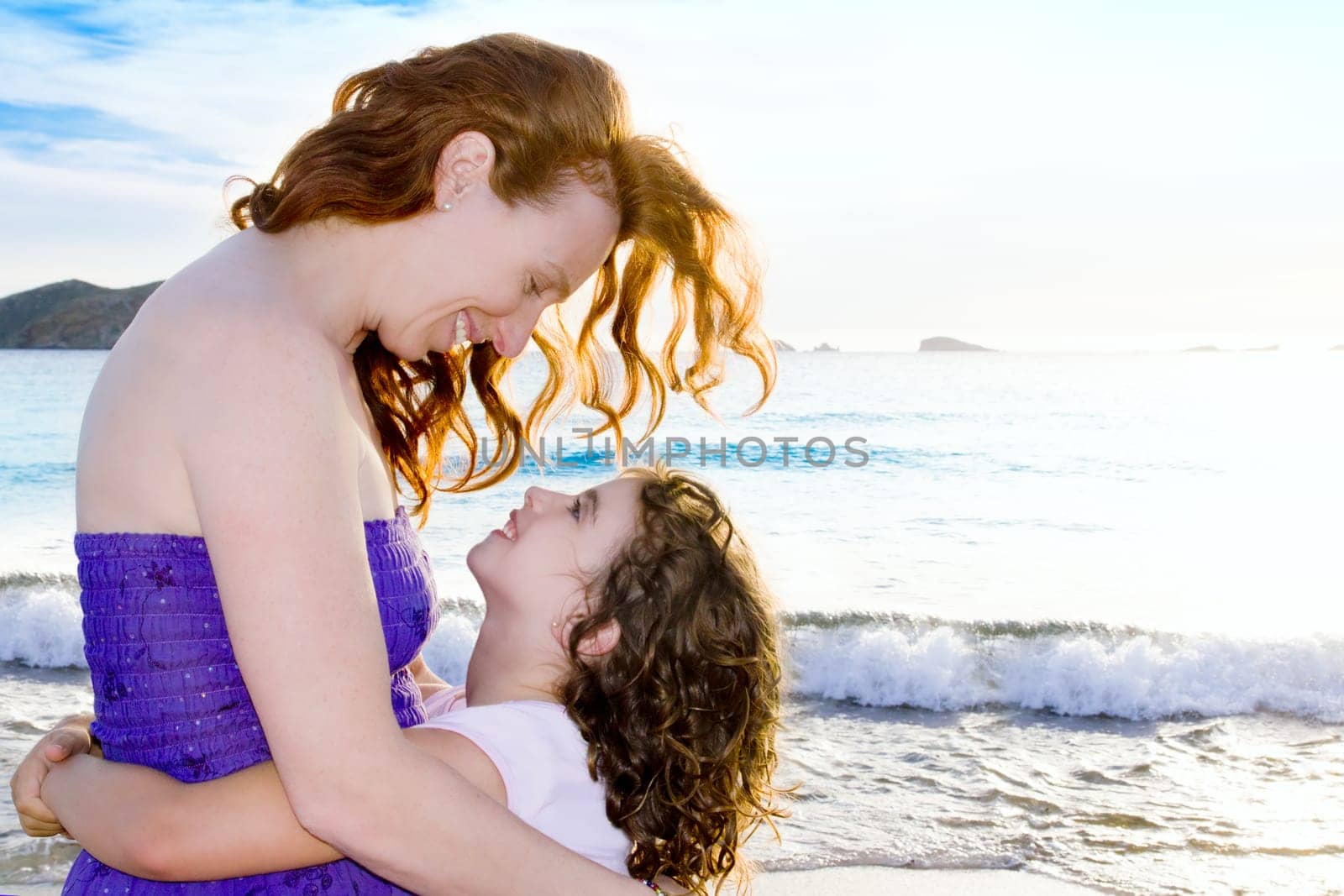 Daughter and mother hug on the beach of Ibiza Cala conta