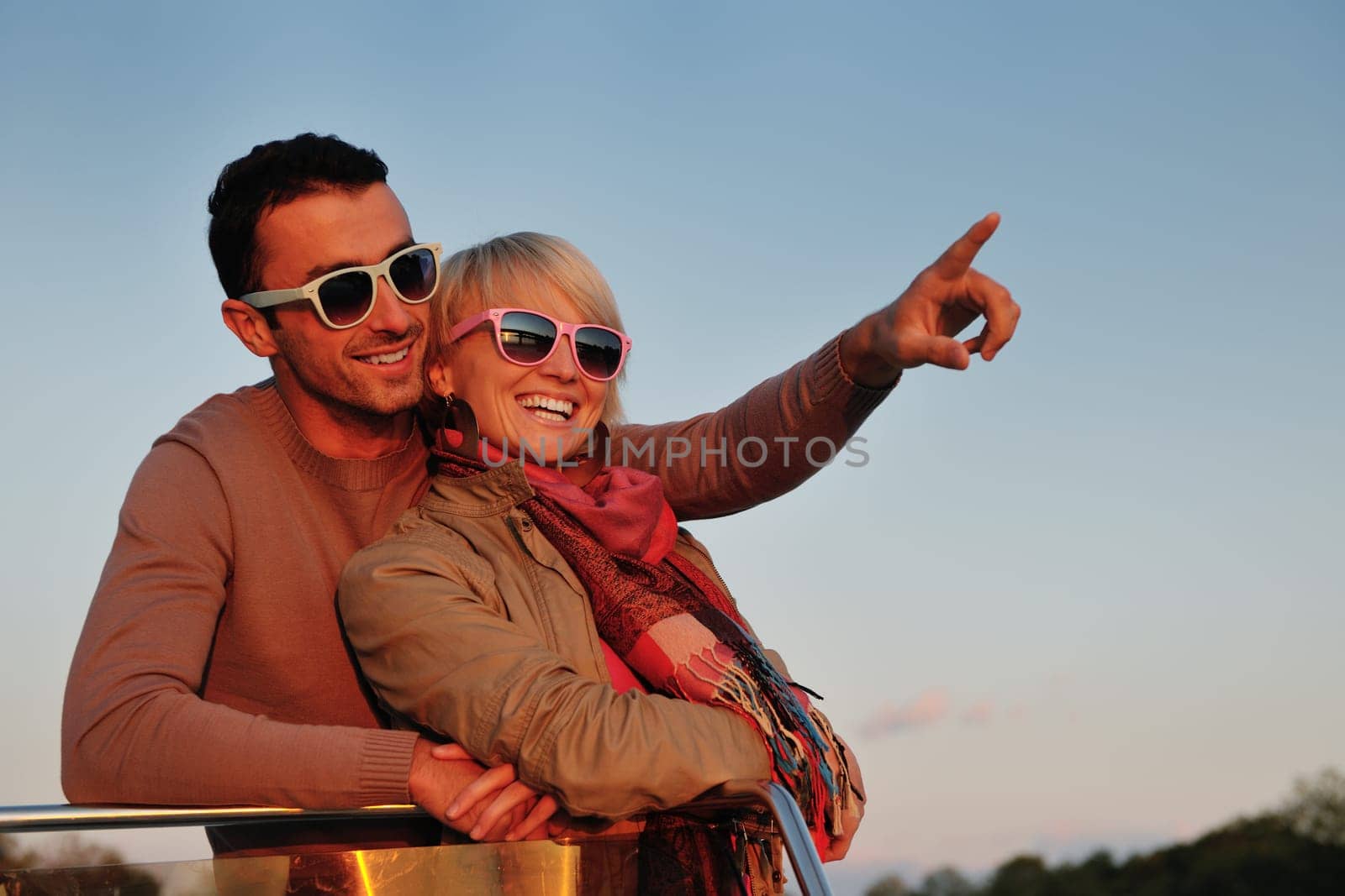 happy young couple in love  have romantic time at summer sunset   at ship boat while  representing urban and countryside fashin lifestyle