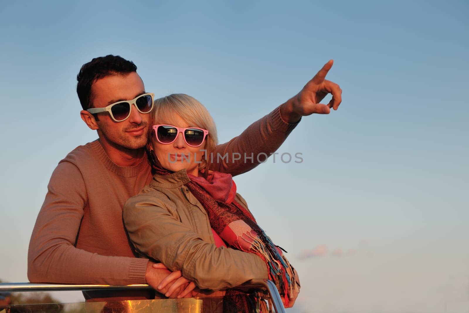 happy young couple in love  have romantic time at summer sunset   at ship boat while  representing urban and countryside fashin lifestyle