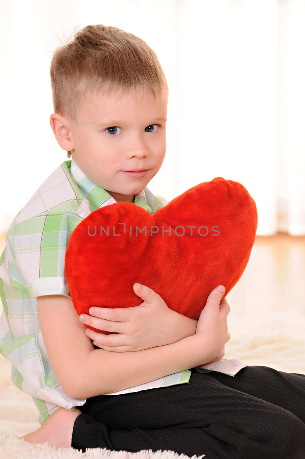 the child sit on the floor with a red plush heart