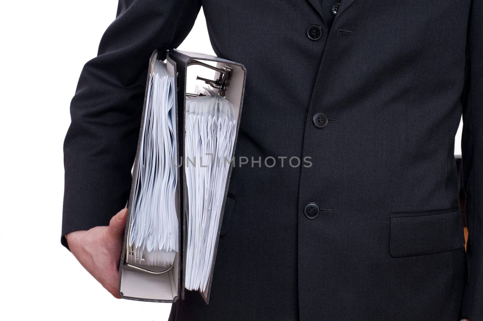 A man in a suit holds two folders under his arm