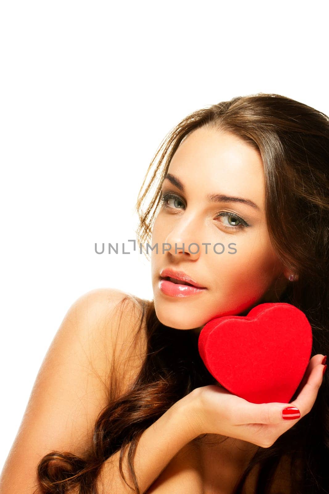 Beautiful brunette woman holding red heart against white background