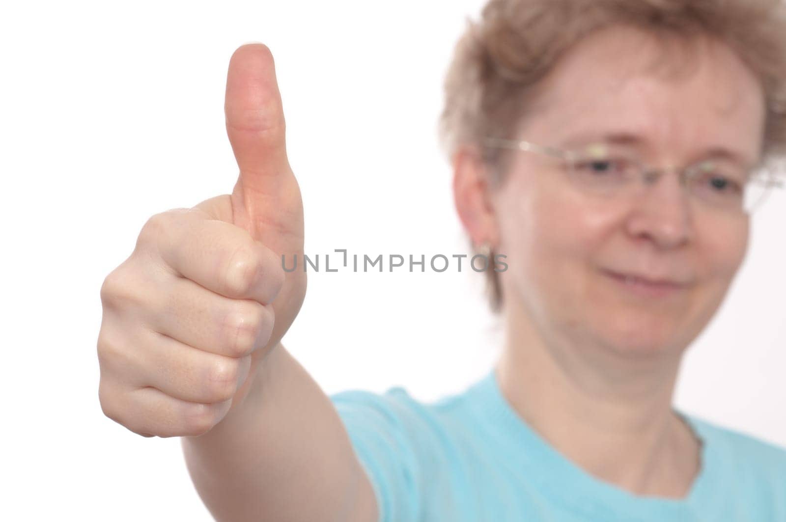 A blonde woman with glasses holds up the thumbs up