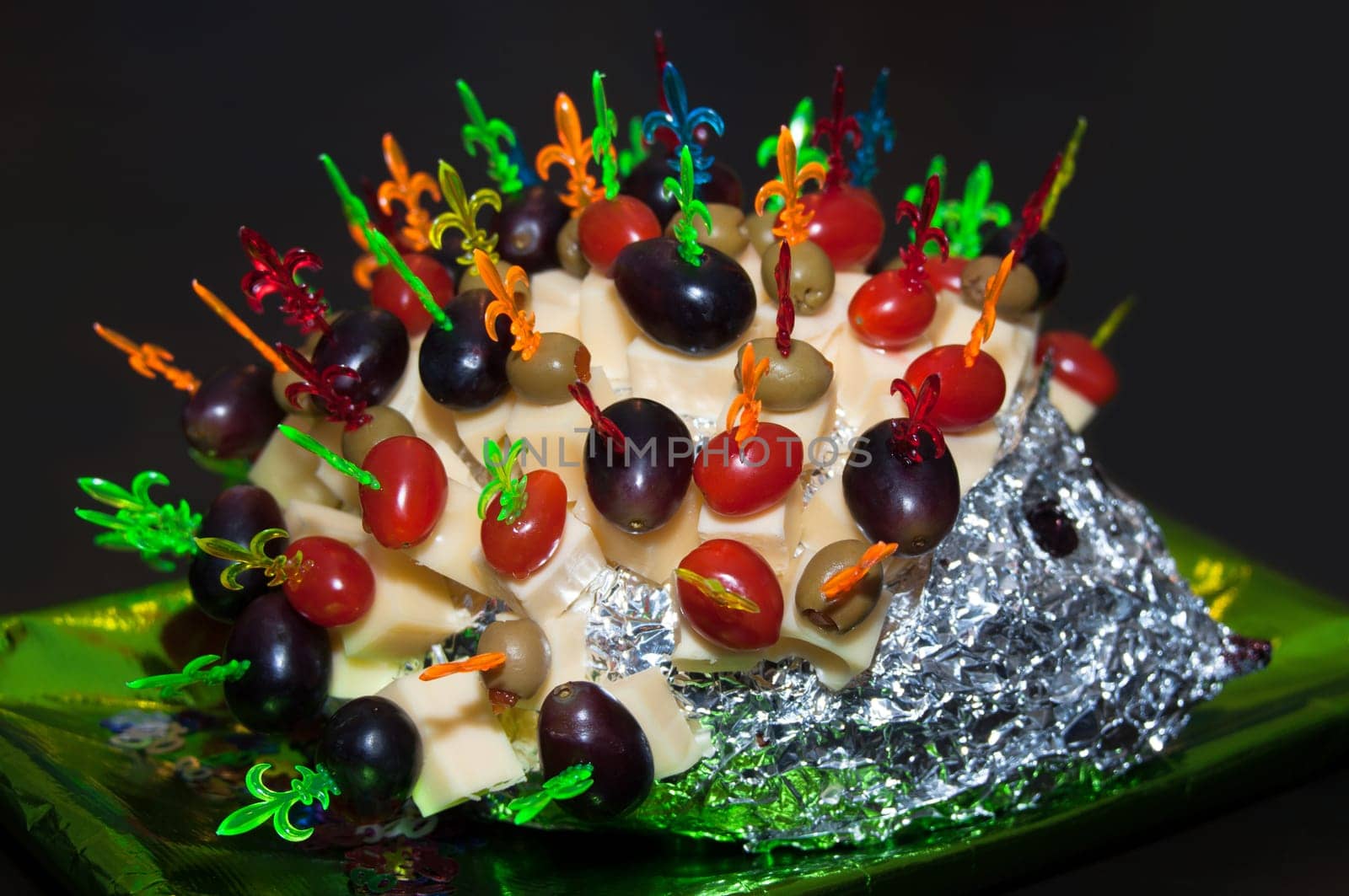 hedgehog made from sticks with delicious food - cheese, olives, tomatoes, grapes