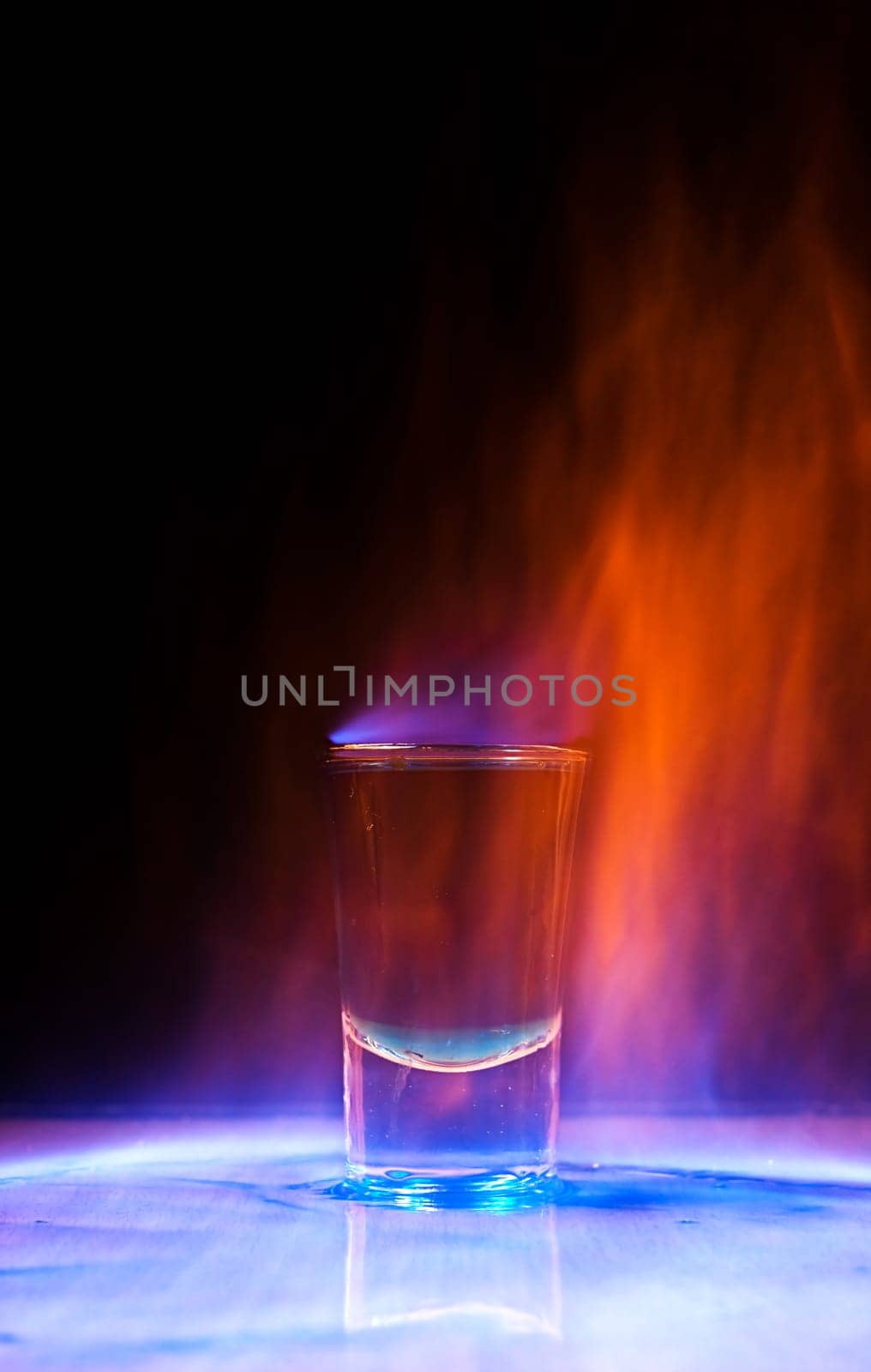 Burning drink in shot glass on a table