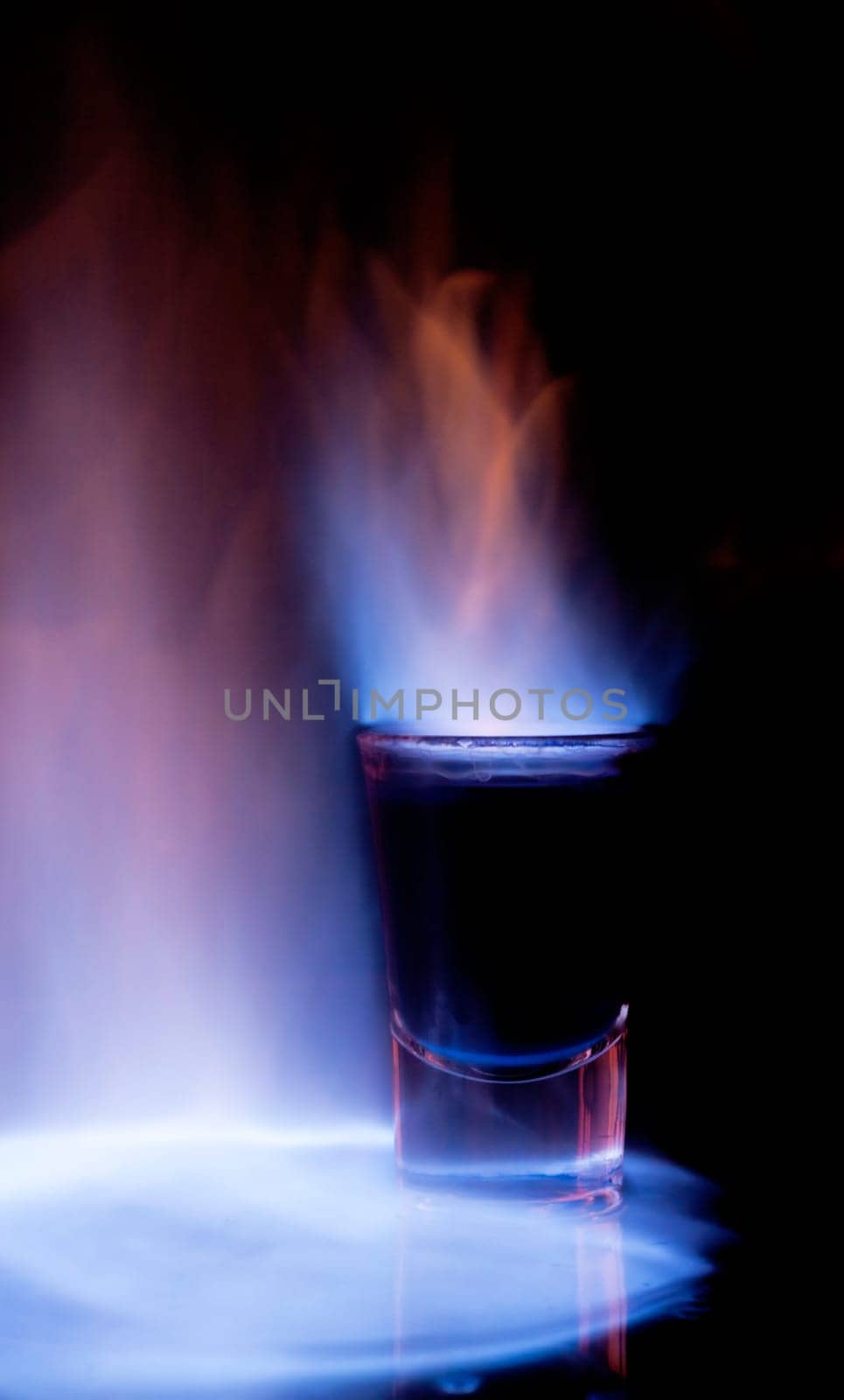 Burning drink in shot glass on a table