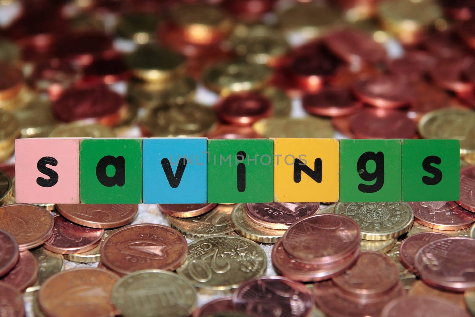 toy letters that savings against a coin background with clipping path