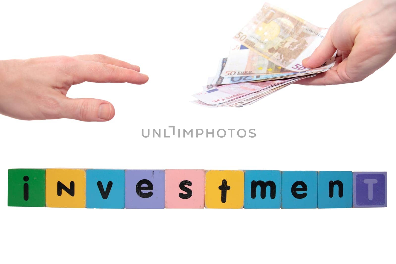 toy letters that spell house investment with cash in hands against a white background with clipping path