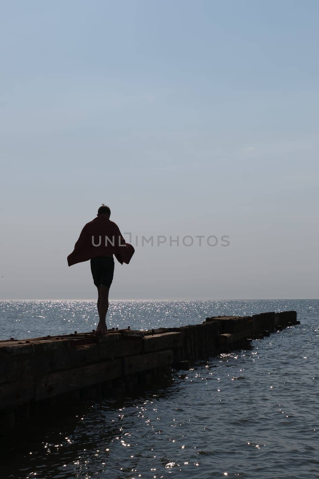 lonely boy go over the pier into the sea