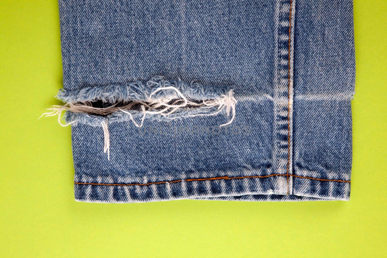 Frayed denim jeans with green background