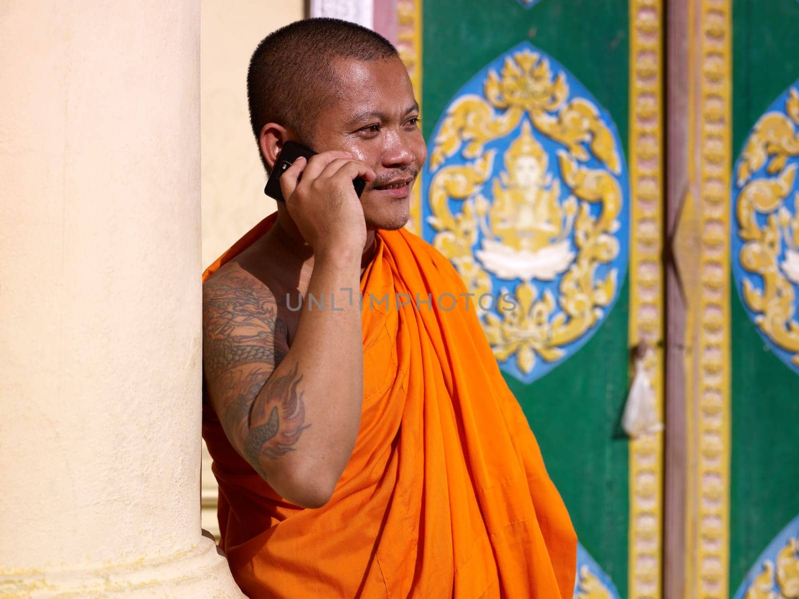 mid adult buddhist monk speaking with cell phone in monastery, Phnom Penh, Cambodia, Asia