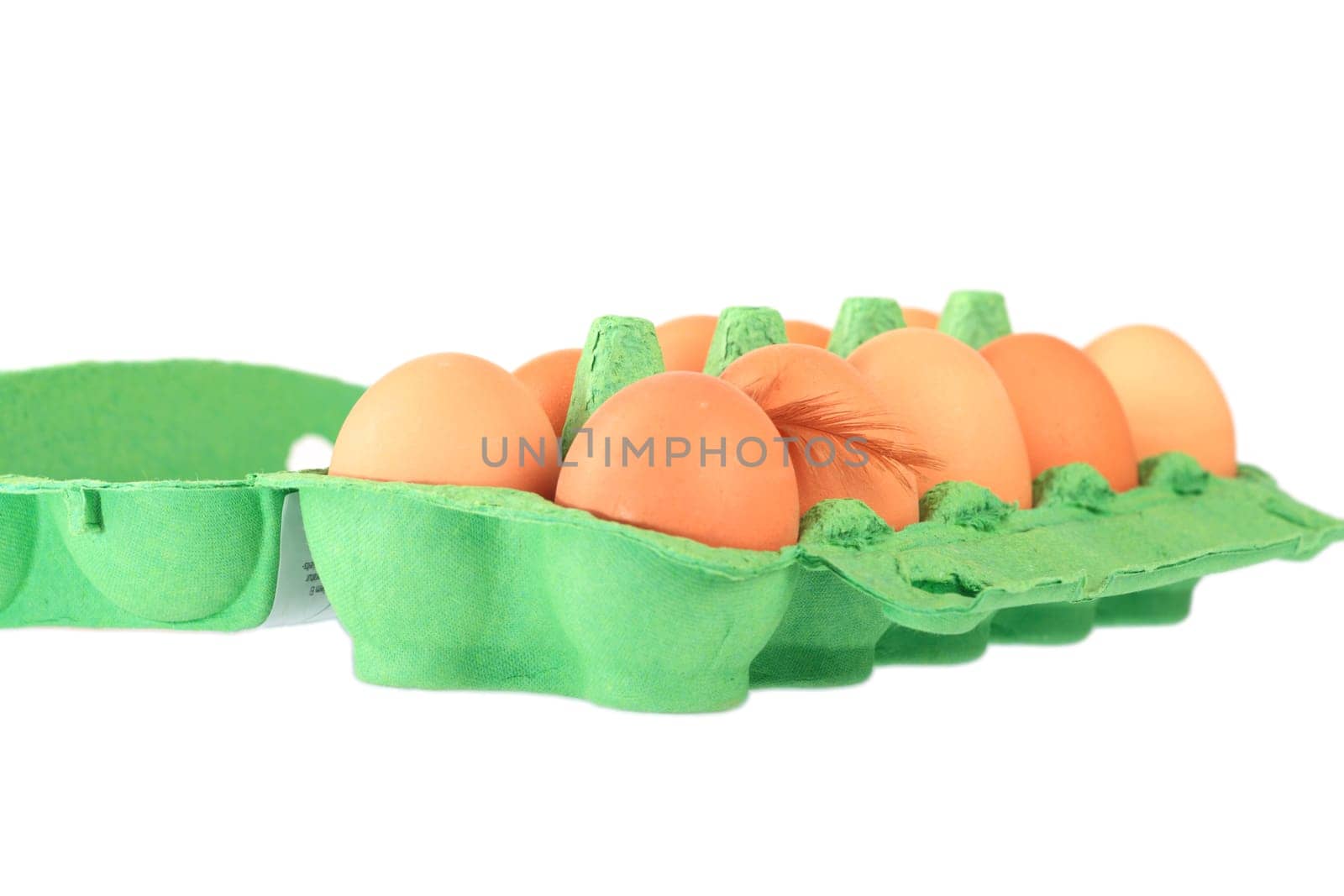 Brown chicken eggs in a cardboard box with down feather