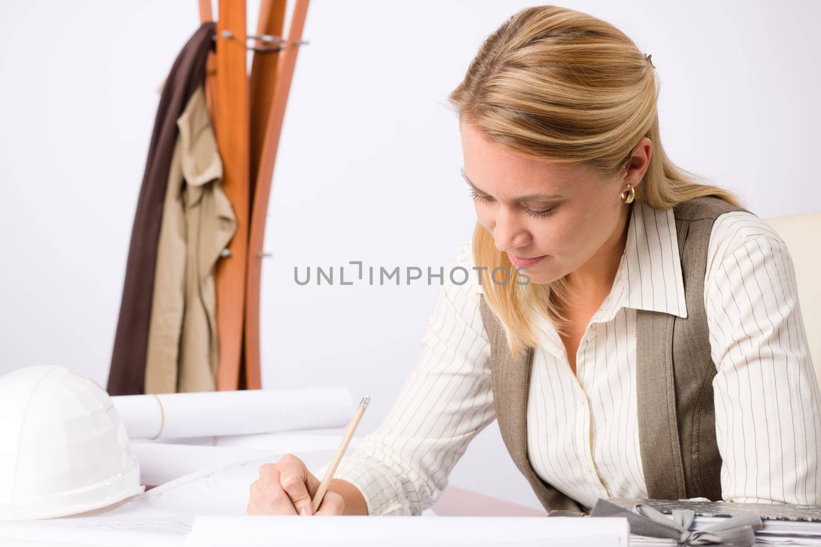 Female architect attractive working on a blueprint sketches in office
