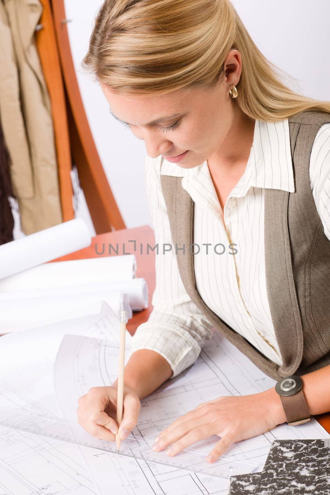 Female architect attractive working on a blueprint sketches in office