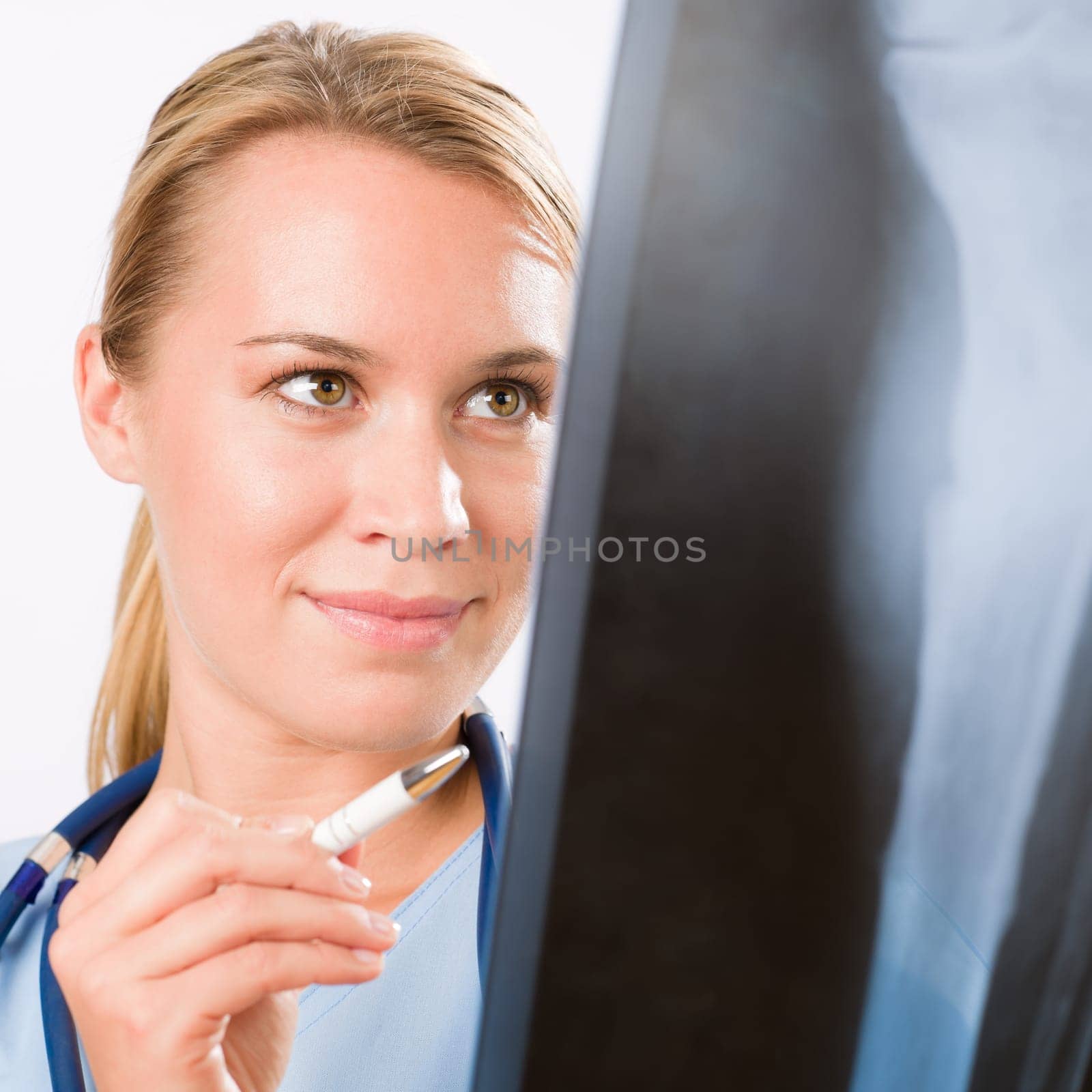 Young female doctor examining x-ray isolated on white background