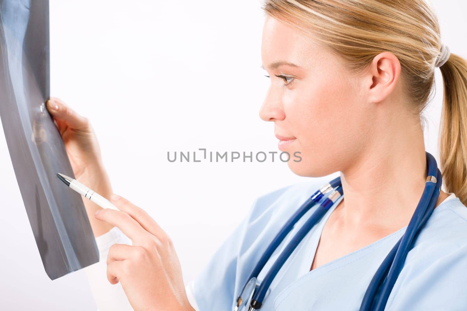 Young female doctor examining x-ray isolated on white background