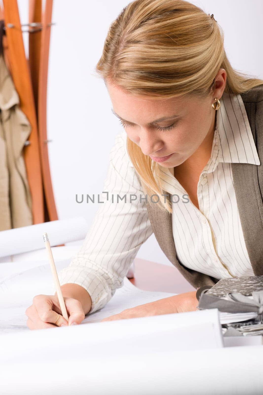 Female architect attractive working on a blueprint sketches in office