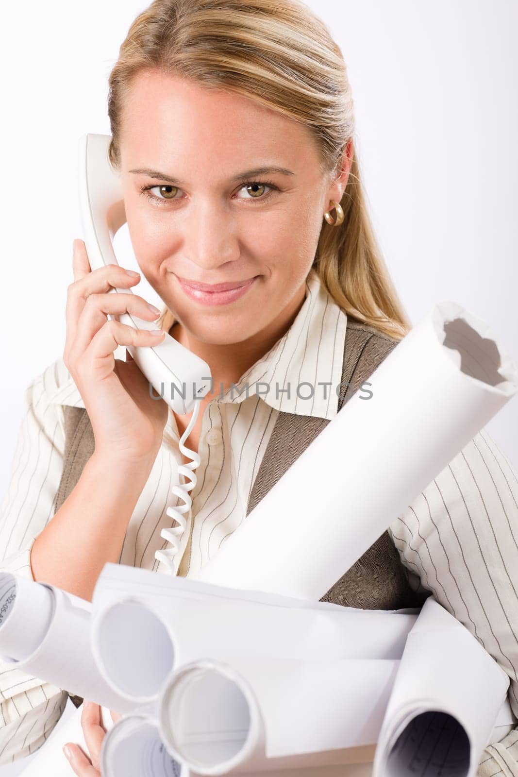 Smiling young female architect holding blueprints isolated on white background
