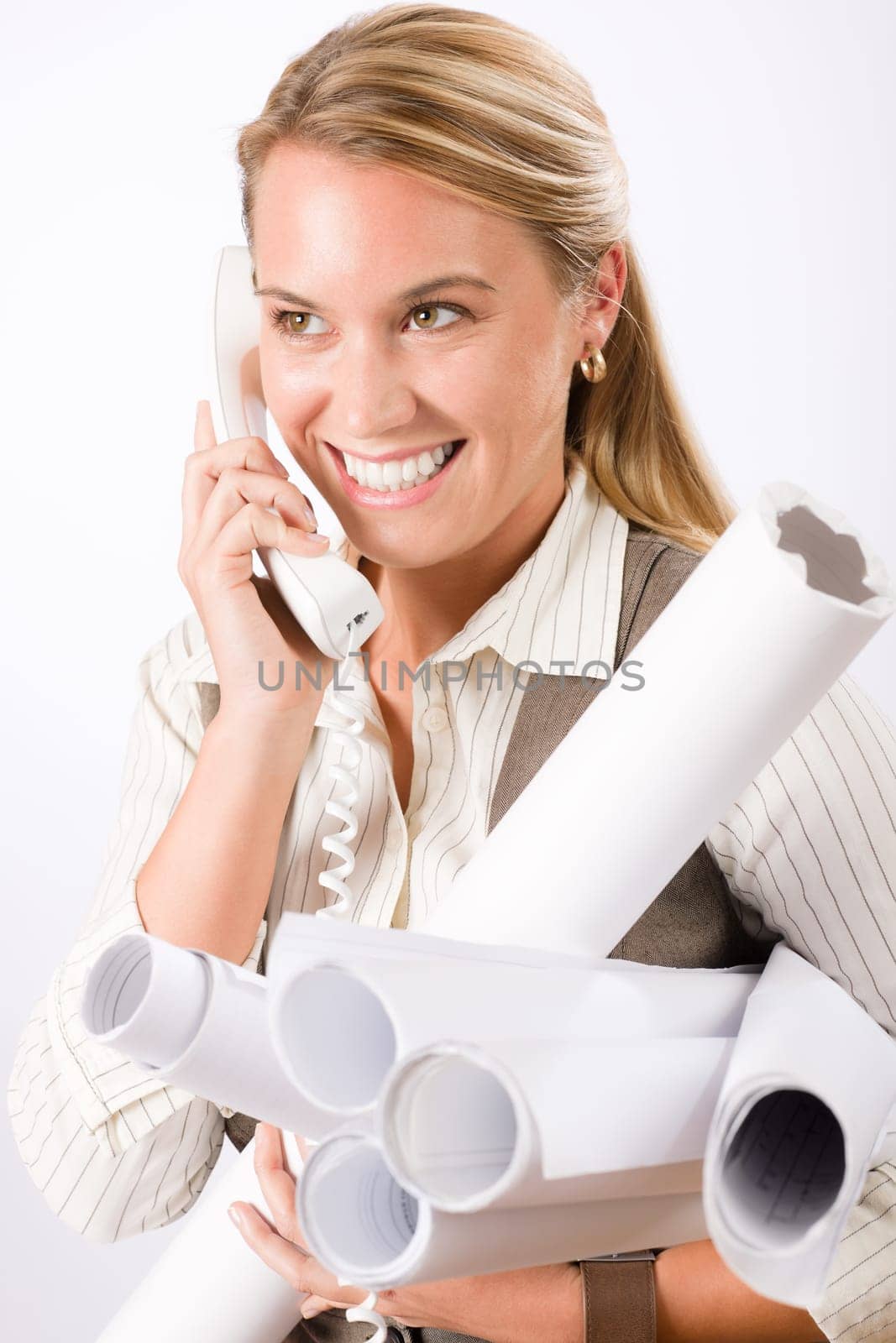Smiling young female architect holding blueprints isolated on white background