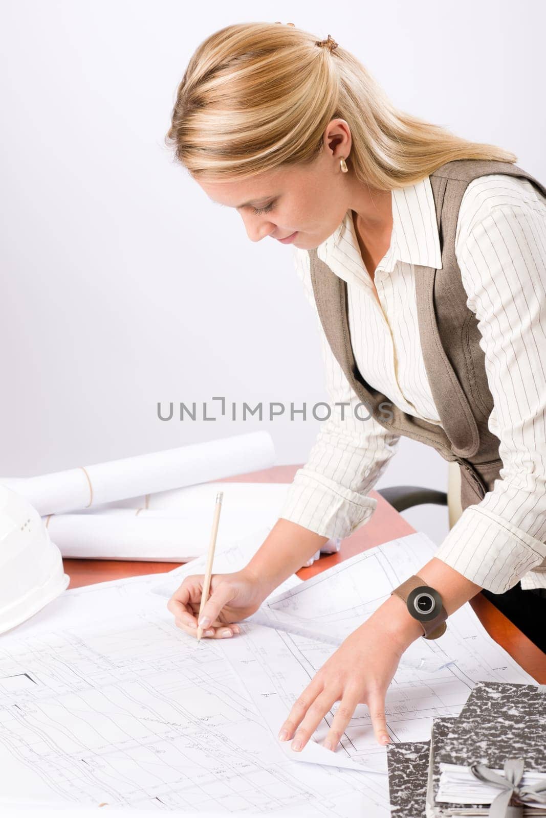 Female architect attractive working on a blueprint sketches in office
