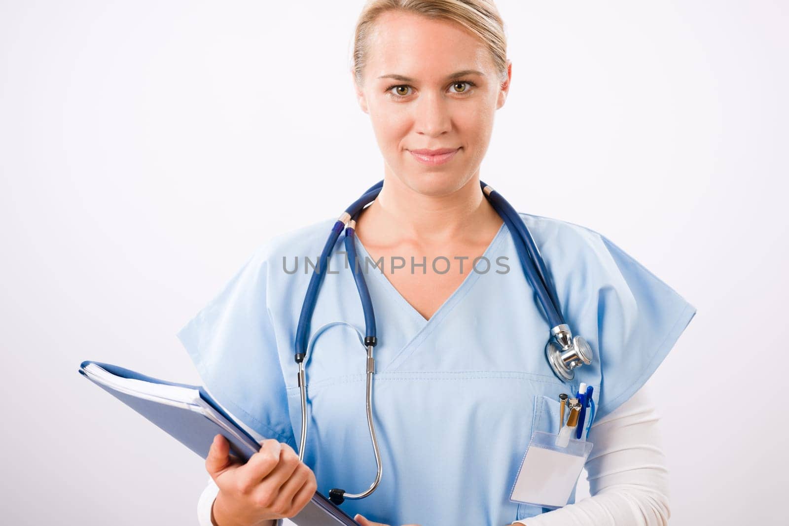 Attractive female doctor standing with stethoscope and folders isolated portrait