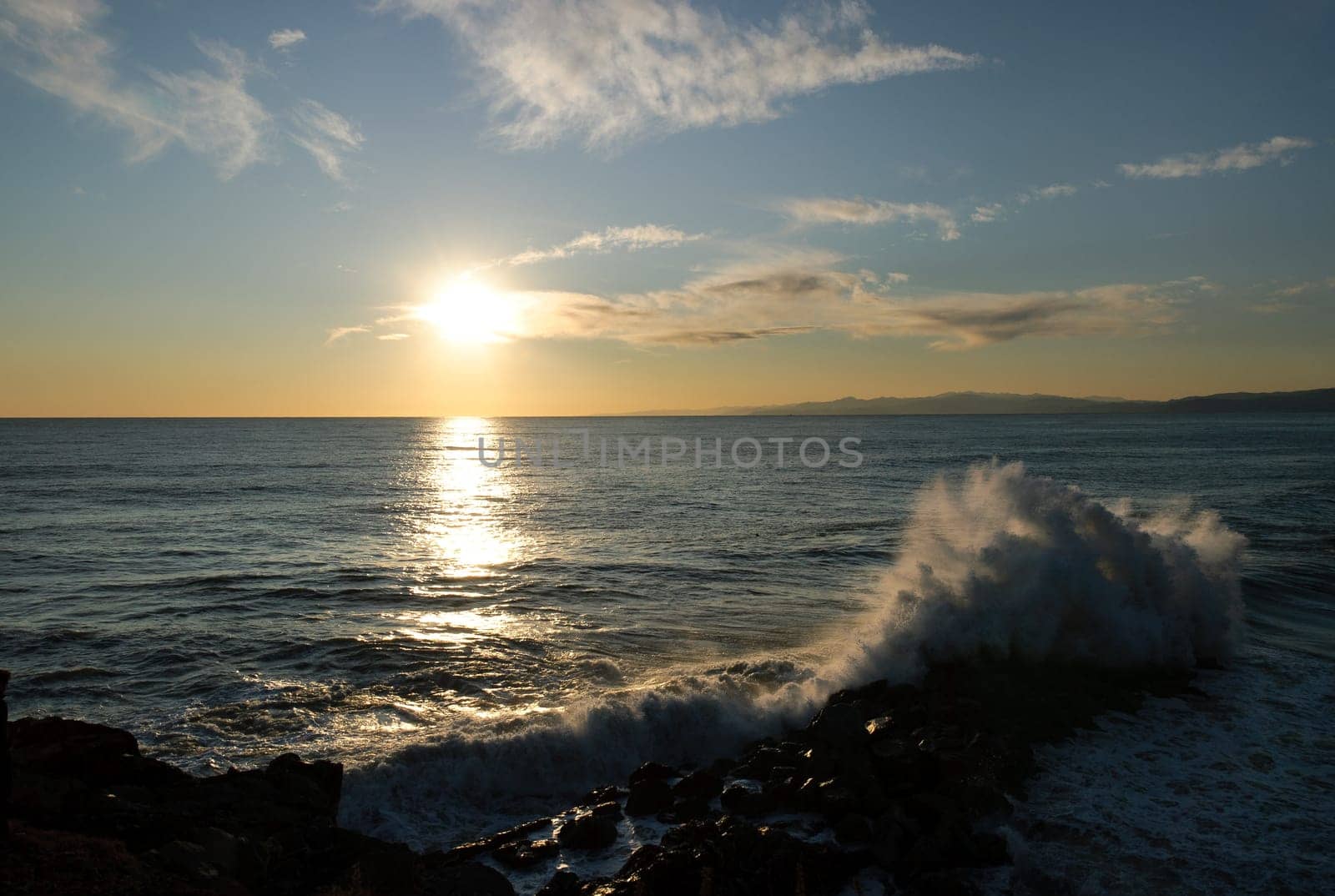wave that is broken on the rocks at sunset